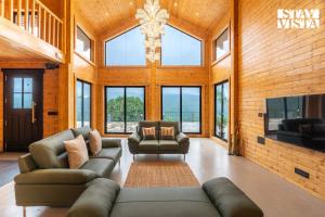 ロナバラにあるStayVista at Apukaa Hills with Karaoke, Poolのソファと椅子とテレビのあるリビングルーム