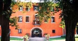 ein orangefarbenes Gebäude mit einer Tür und einem Innenhof in der Unterkunft Villa Chiopris in Chiópris-Viscone