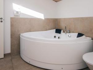 a white bath tub in a bathroom with a toilet at 6 person holiday home in Bjert-By Traum in Sønder Bjert