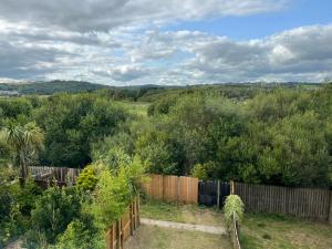 a backyard with a wooden fence and trees at South Wales Coastal Retreat in Llanelli