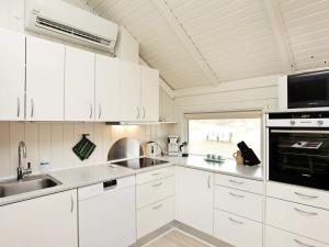 a white kitchen with white cabinets and a sink at Modern Beach House - By Traum Ferienwohnungen in Vejers Strand