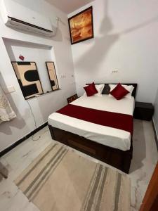 a bedroom with a bed with red pillows at Olivstays by Offbeat in Udaipur