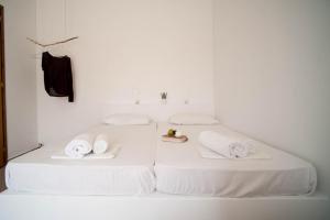 two beds with white sheets and towels on them at Giosifaki in Vári