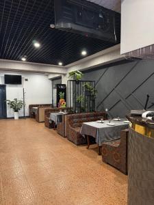 a restaurant with tables and couches in a room at Mehran Hostel in Andizhan