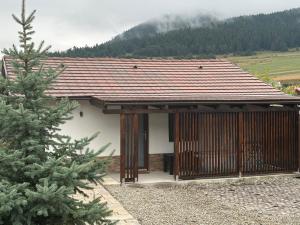 a small house with a roof and a pine tree at Aqua Garden Junior Miercurea Ciuc in Miercurea-Ciuc