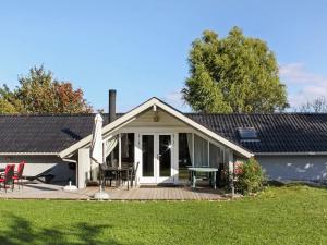a house with a deck and a table and chairs at 4 star holiday home in Sydals in Sarup