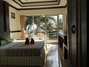 una camera da letto con un letto con delle scarpe rosse sopra di Plaloma Cliff Resort a Ko Chang
