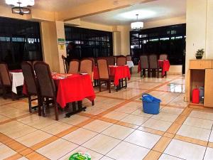 a dining room with tables and chairs and red table cloth at Pink Lounge Suites in Nairobi