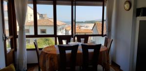 a table with chairs in a room with a large window at Tercero Loft Susana in San Vicente de la Barquera