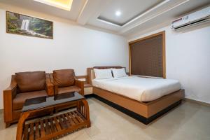 Un dormitorio pequeño con una cama y un sofá. en Hotel Staymax Trend kannur, en Kannur