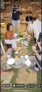 a group of people sitting around a table with food at A Ơi Di Linh homestay 
