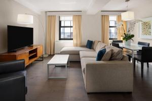 a living room with a couch and a tv at The Beekman Tower, Trademark Collection by Wyndham in New York