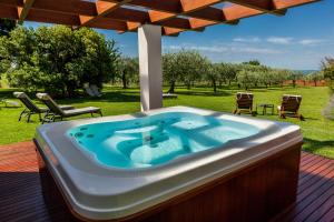a hot tub on a deck with an umbrella at Quercia Belvedere Relais in Bardolino
