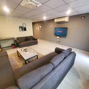 a living room with a couch and a flat screen tv at Private Suite with Private Entrance - Self Check in - F-8 - Private Parking in Islamabad +17 photos