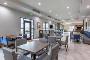 a restaurant with tables and chairs and a couch at Comfort Suites Scottsdale Talking Stick Entertainment District in Scottsdale