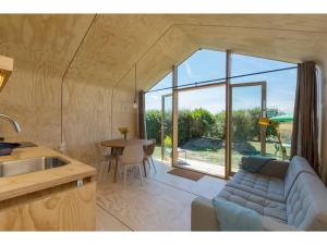 una sala de estar con un sofá y una mesa en Tiny House in Zeeland near Oranjezon Dunes, en Vrouwenpolder