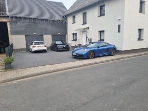 two cars parked in a parking lot next to a building at CJS Apartments - Chill or Drive am Nürburgring, Free Parking, WLan, Spacious Rooms, Quiet Location in Rodder +85 photos