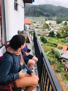 a group of girls sitting on a balcony looking at their cell phones at Avocado City Guest Nuwaraeliya in Nuwara Eliya +6 photos
