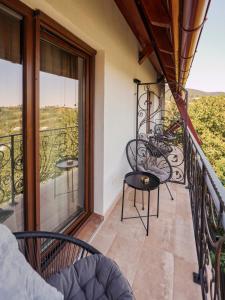 a balcony with chairs and a table and a view at Bungalou Ikabane in Văratec +19 photos