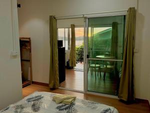 a bedroom with a bed and a sliding glass door at Colibri Beach Resort in Chaloklum