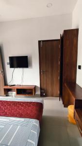 a bedroom with a bed and a flat screen tv at Nelleri Residency Managed By Vaishno Hospitality in Iritti