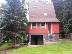 a red house with a red roof on a green field at House in Bohemian near Ski Slope in Mezihoří