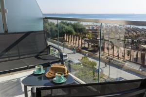 a table with two cups and a hat on a balcony at Exotic Sunrise View in Infinity Pool & Spa Resort in Mamaia Sat/Năvodari