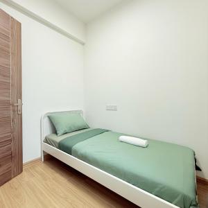 a bed in a white room with a green mattress at Regalia Park 2B1R 3pax Near Beach Forest City GB A-1202 in Gelang Patah