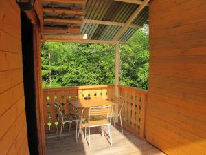 - une terrasse couverte en bois avec une table et des chaises dans l'établissement Apartment Zalokar, à Bohinj