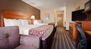 a hotel room with a bed and a tv at Best Western Manhattan Inn in Manhattan