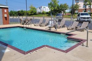 a large swimming pool with chairs and a fence at Comfort Inn Bessemer Birmingham South in Bessemer