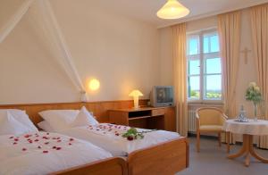ein Hotelzimmer mit 2 Betten mit Rosen in der Unterkunft Heilbad Krumbad in Krumbach