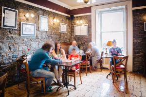 un grupo de personas sentadas en una mesa en un restaurante en Gleeson's Restaurant & Rooms, en Roscommon