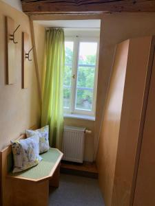 a room with a window and a bench with pillows at Gästehaus zur ehemaligen Mehlwaage wohnen und genießen in Bamberg +13 photos