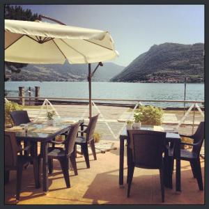 een tafel en stoelen met een parasol op een patio bij A Lago in Marone