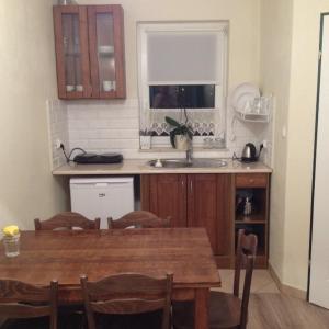 a kitchen with a wooden table and a sink at Białe domki in Jastrzębia Góra