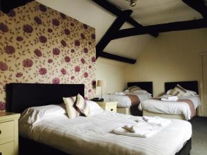a bedroom with two beds with towels on them at Plas Coch Hotel Ltd in Bala