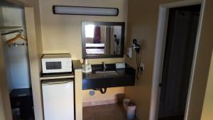 a bathroom with a sink and a microwave at Anaheim Astoria Inn & Suites in Anaheim