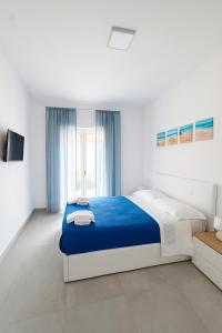 a bedroom with a blue and white bed and a window at Home & Garden in Vico Equense