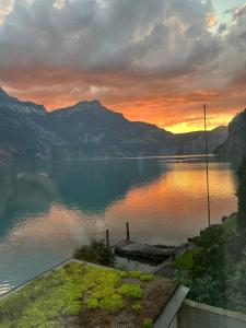 a view of a lake at sunset with mountains at Exclusive Lake Access Villa Studio in Fluelen