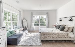 Un dormitorio blanco con una cama y un sofá. en Large Luxury House with Rooftop deck--only 5 min walk to Metro, en Falls Church