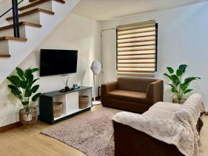 a living room with a couch and a television at ELISA'S 3 Bedroom with pool in San Pablo