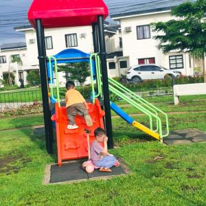 two young children playing on a playground equipment at ELISA'S 3 Bedroom with pool in San Pablo +11 photos
