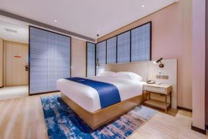 a large bedroom with a large bed and a desk at Echarm Hotel Guizhou Xingyi Jushan Avenue in Xiawutun +185 photos