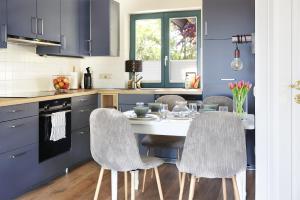 eine Küche mit einem weißen Tisch und Stühlen in der Unterkunft Hus Föfftein in Hellschen-Heringsand-Unterschaar + 13 Fotos