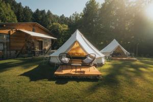 two tents in the grass with a table and chairs at Natur Resort Jetřichovice in Jetřichovice