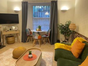 a living room with a green couch and a table at Cosy Flat in Heart of Edinburgh in Edinburgh