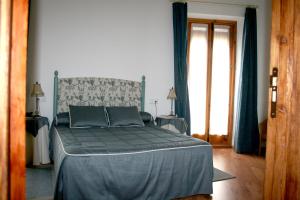 a bedroom with a bed with a blue comforter at La Casona de Mahora in Mahora