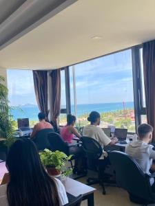a group of people sitting at tables with laptops at Waikiki Beach Hotel Da Nang in Da Nang