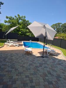 a pool with a white umbrella and two chairs and a pool at phranta in Gonio
